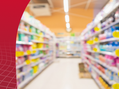 A blurred retail aisle featuring various consumer goods, illustrating the need for liquid packaging innovations that stand out on the shelf in 2026.