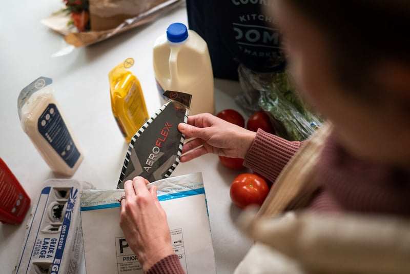 Person taking an AeroFlexx Pak out of a padded envelope