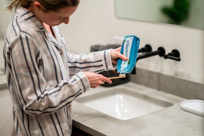 Woman putting toothpaste on her toothbrush