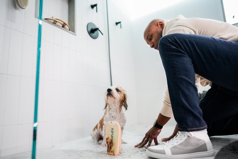 Man washing his dog with AeroFlexx pet shampoo