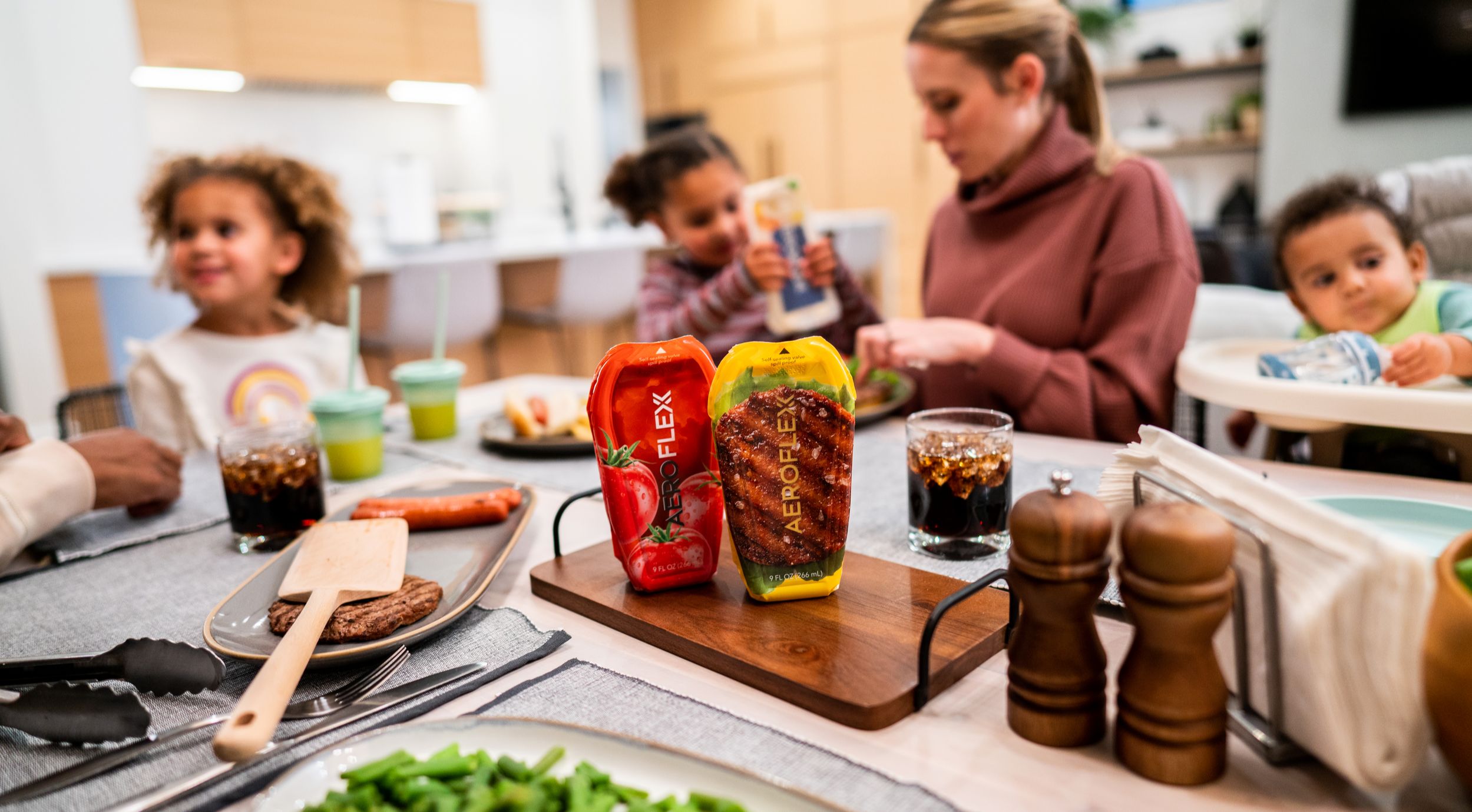 Family enjoying meal in the kitchen with ketchup and mustard in AeroFlexx Paks